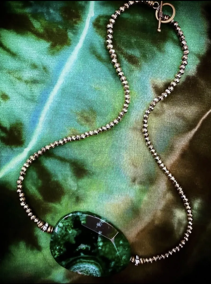 Silver beaded necklace with a green stone pendant